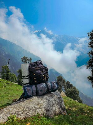 Captivating view of trekking gear against the Himalayan mountains in HP, India.